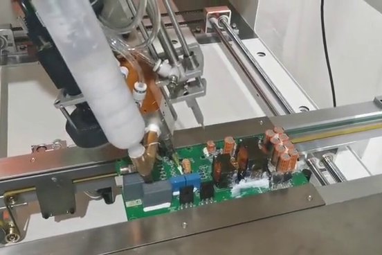 Robot FAIRINO dozuje materiał na płytkę elektroniki.